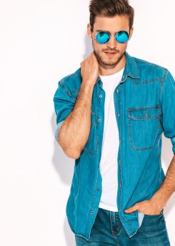 Portrait of handsome smiling stylish hipster lumbersexual businessman model dressed in jeans clothes and sunglasses. Fashion man isolated on white